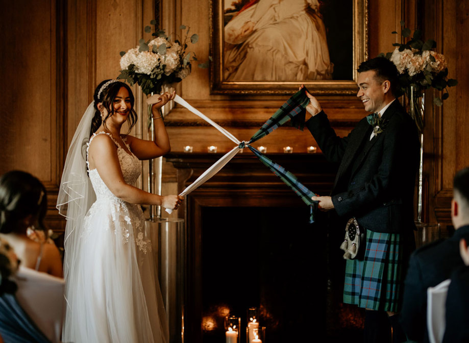 Bride and groom take part in a handfasting during their wedding ceremony