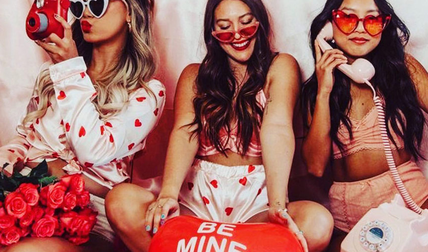 a group of women wearing sunglasses and holding a heart shaped balloon