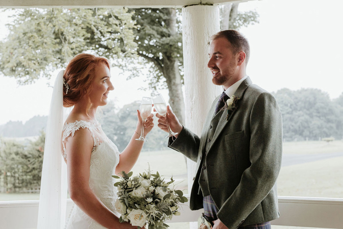 A Bride And Groom Cheers With Champagne Glasses