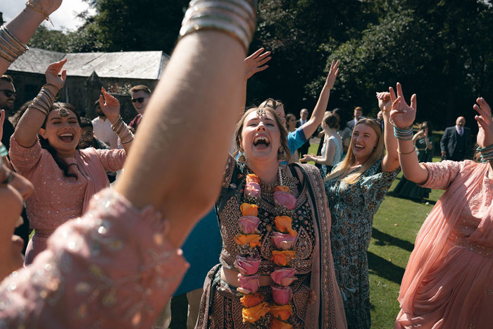 A person in a sari with her arms raised.