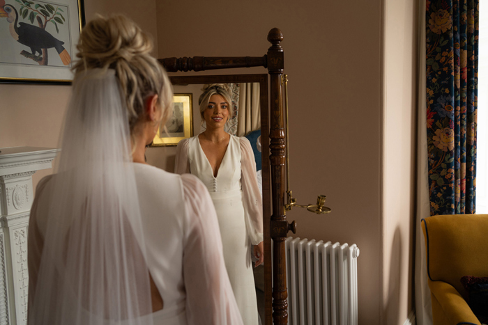 Bride looks at herself in the mirror