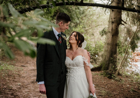 bride and groom looking at each other in a woodland