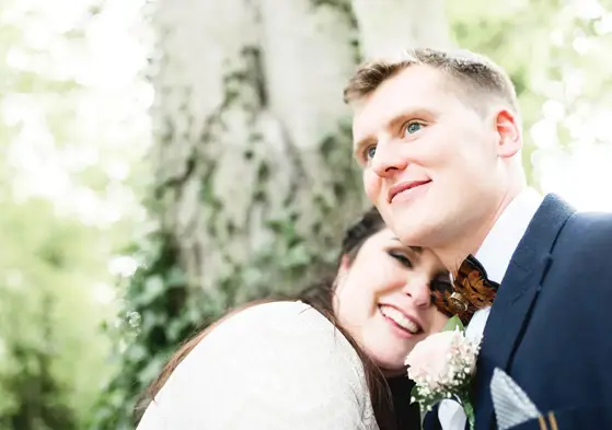 Bride with head on grooms shoulder, both smiling