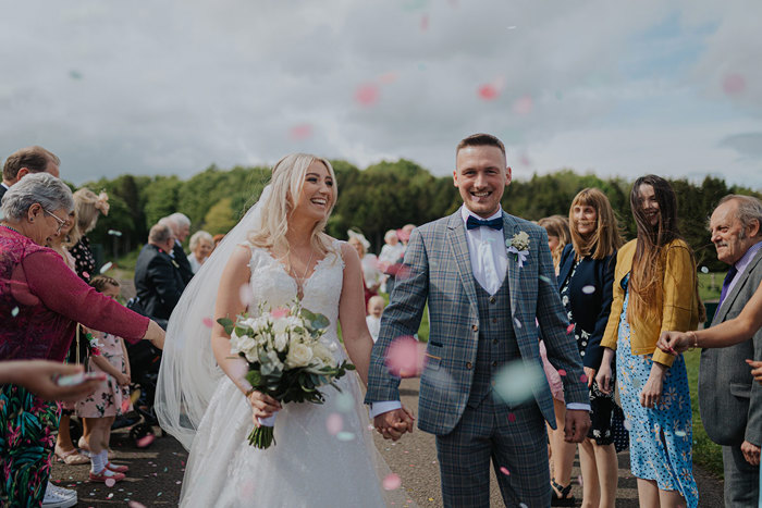 A Bride And Groom Walk Through Confetti Thrown By Guests Outside Forbes Of Kingennie