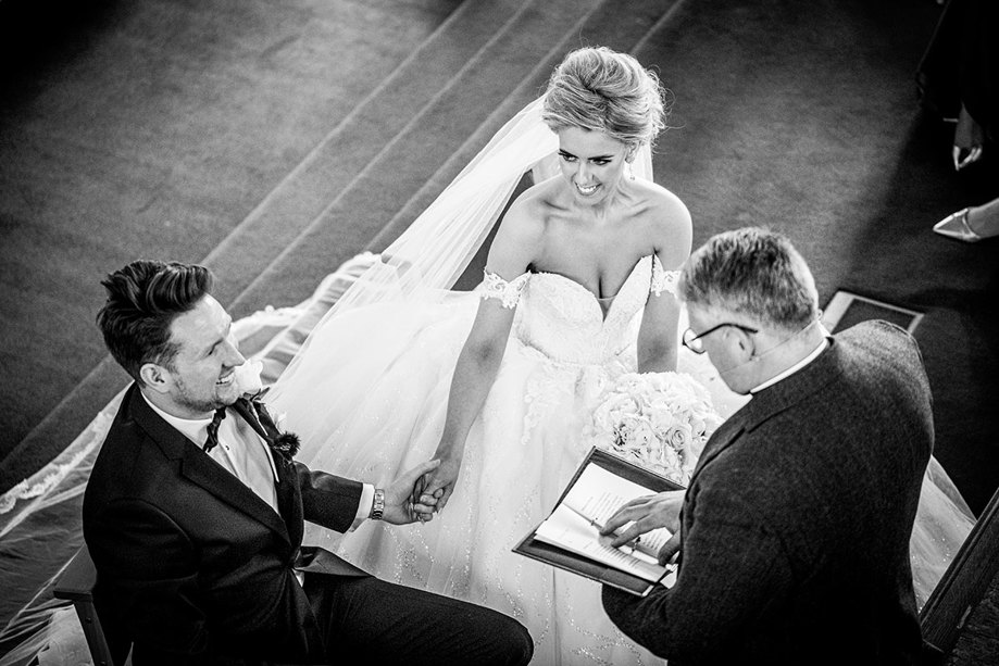 A Black And White Image Of A Bride And Groom During A Wedding Ceremony At St Peters & St Andrews Church