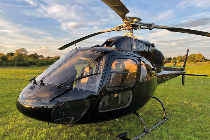 a black helicopter grounded on a green lawn