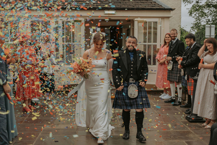 Couple walk through confetti shower