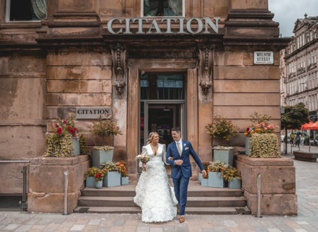 couple walking down steps of Citation wedding venue in Glasgow after getting married 