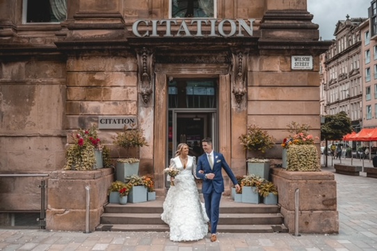 couple walking down steps of Citation wedding venue in Glasgow after getting married 