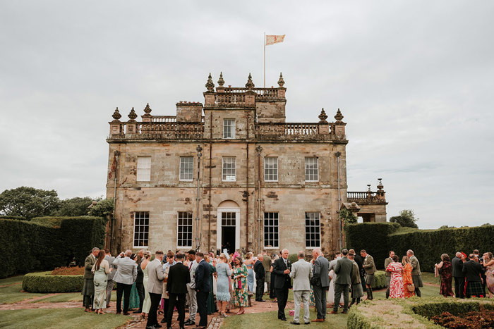 Wedding guests gathered in the garden of a country house