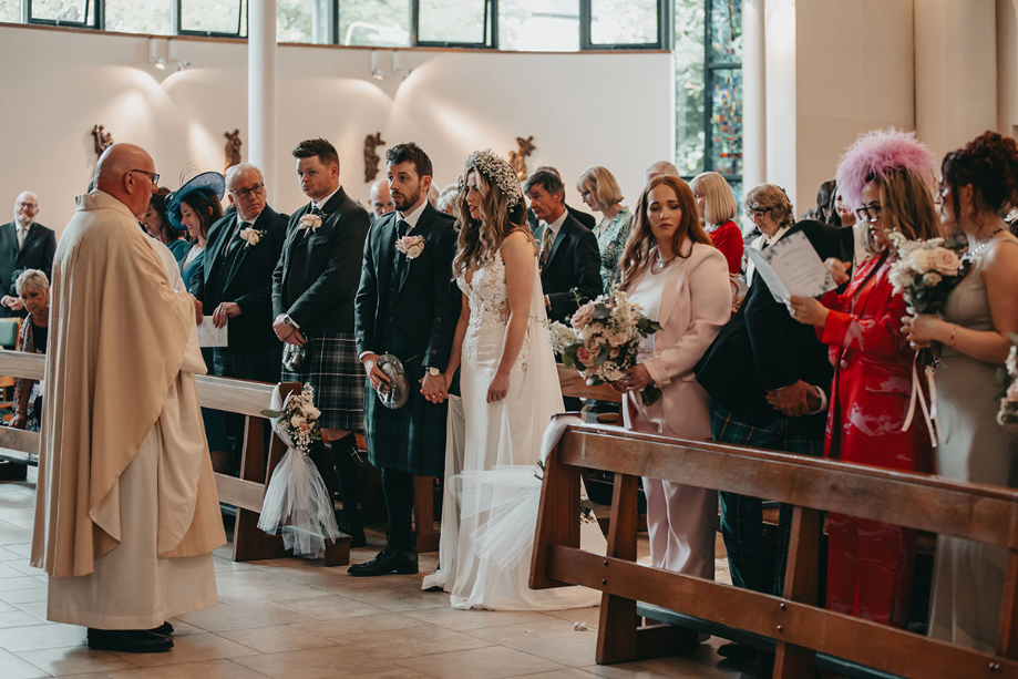 Bride and groom hold hands during their wedding ceremony