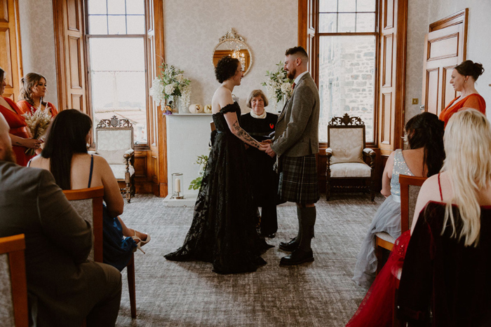 Bride and groom hold hands during the ceremony 