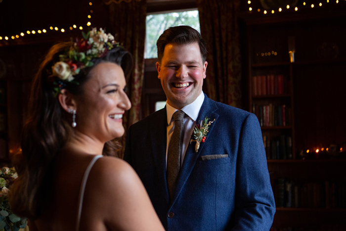 Bride and bridesmaid laugh during the ceremony