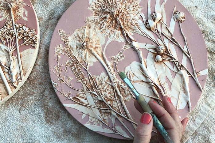 hand painting cast of flowers  in pink and white with paintbrush