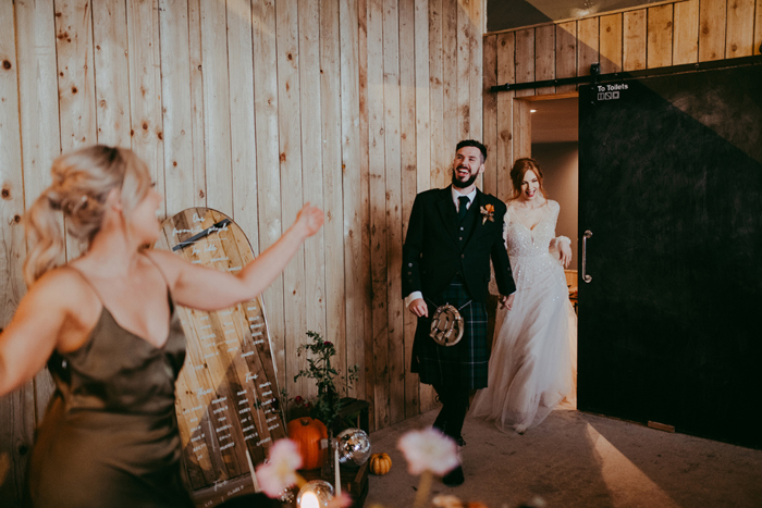 Bride and groom enter wedding venue hand in hand