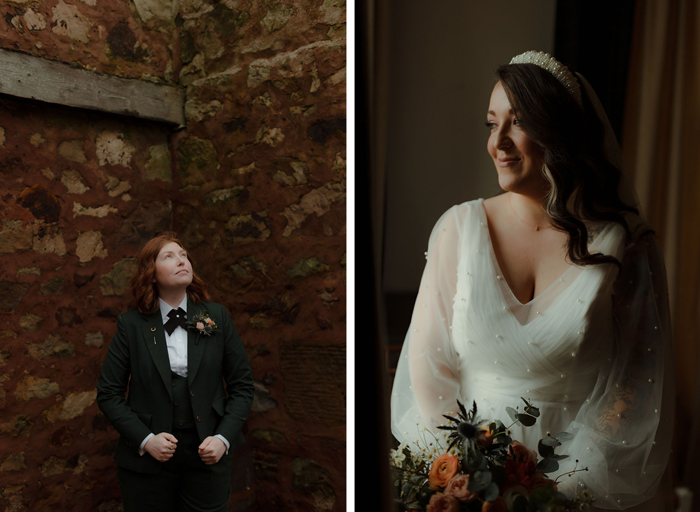 A bride poses against a rustic stone building wearing a smart dark green suit with bow tie on left. A bride wearing a wedding dress dotted with pearls and a chunky ivory headband smiles and holds a wedding bouquet