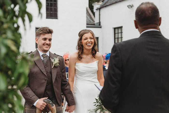 Bride and groom laugh during their wedding ceremony