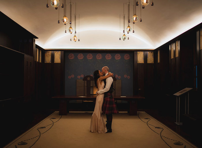 a couple embracing in front of a fireplace in a dark room