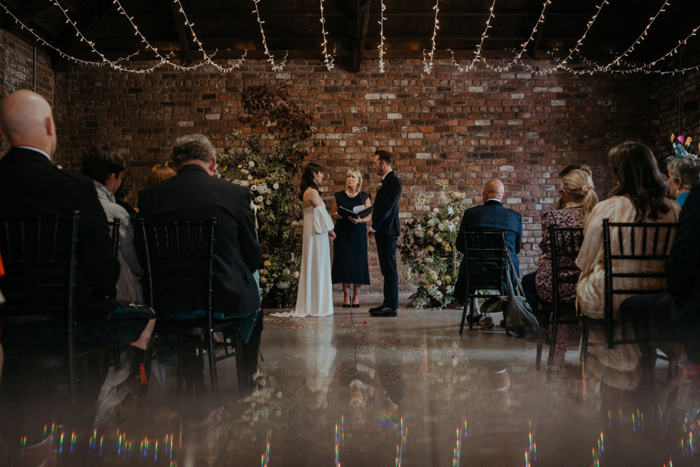 Couple hold hands during ceremony