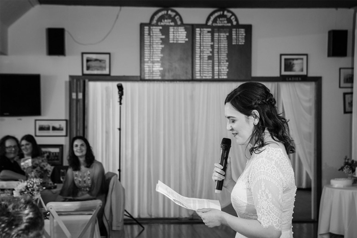 Bride Making A Speech At A Wedding As Guests Watch On