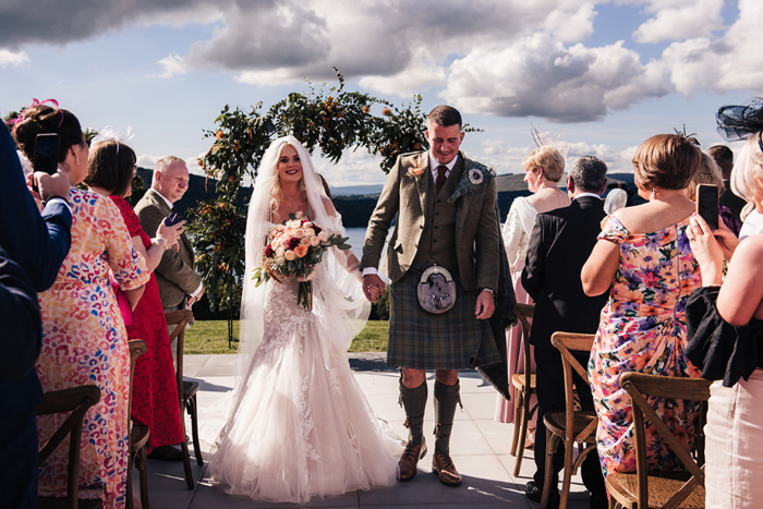 Bride and groom walk up the aisle as newlyweds