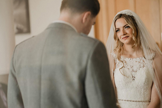 bride looking at groom lovingly at the top of the aisle 