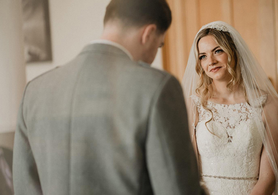 bride looking at groom lovingly at the top of the aisle 