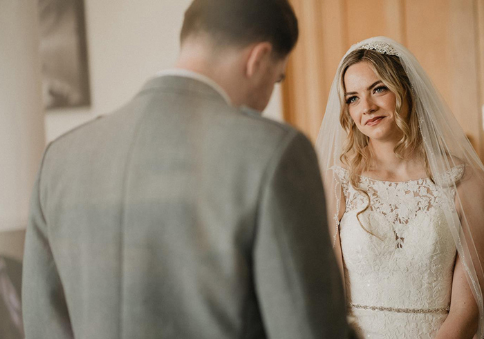 bride looking at groom lovingly at the top of the aisle 