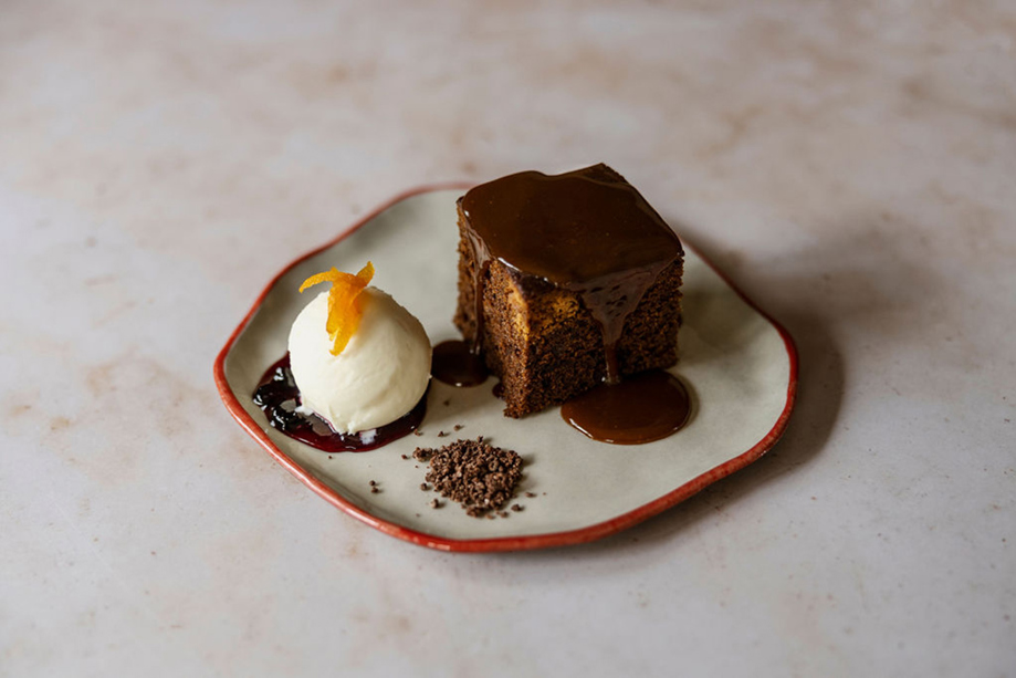 Dessert with garnished ice cream on a red plate