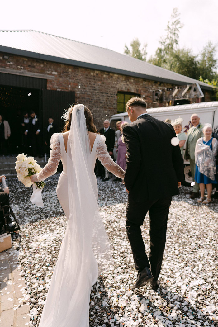 a bride and groom walking hand in hand outside the Engine Works