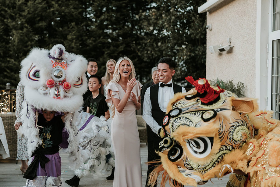wedding guests with Chinese lion dancers outside Busby Hotel