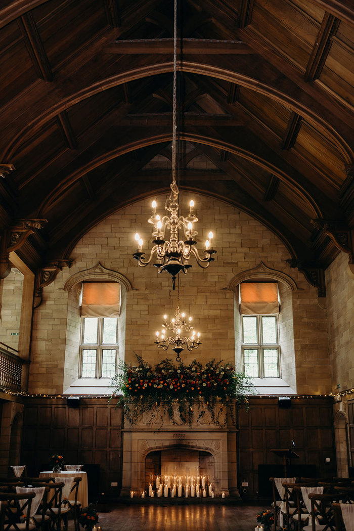 a wooden ballroom with large stone fireplace filled with candles at Achnagairn Castle