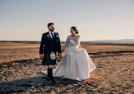 Bride and groom Walking On Beach At Troon