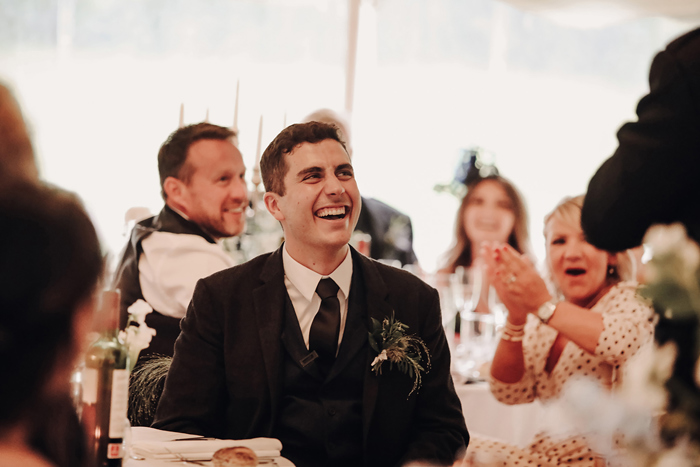 A Person Wearing A Suit Jacket And Tie Laughing