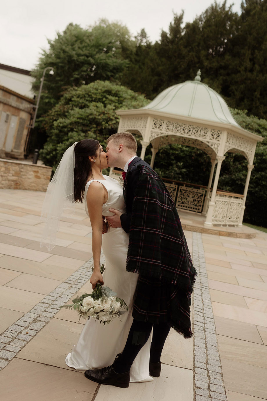 bride and groom kiss on wedding date at kilmardinny house in bearsden