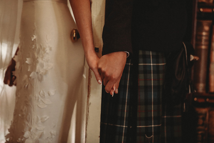 A Bride And Groom Holding Hands During A First Touch