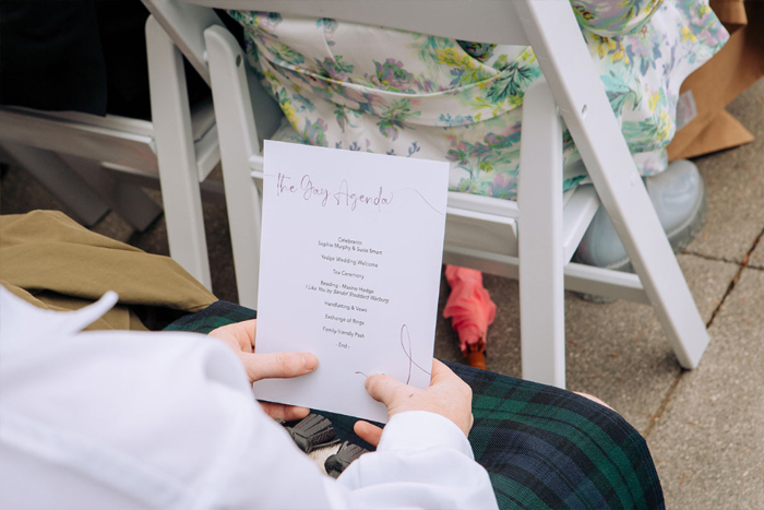 A Person In A Kilt Holding The Gay Agenda Ceremony Running Order