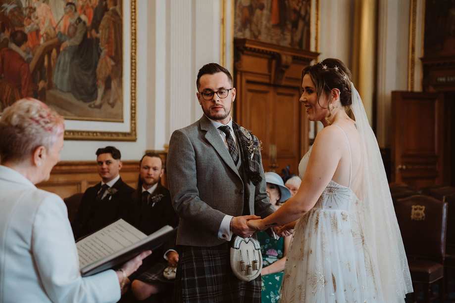 Bride and groom hold hands during the ceremony 