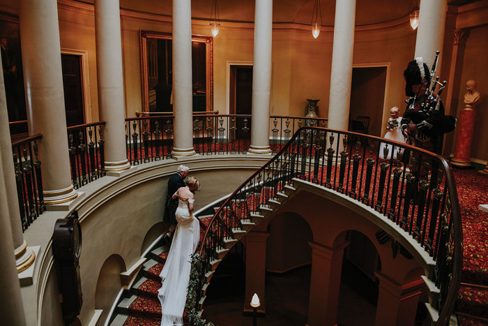 a bride and a person walking up the oval staircase at Culzean Castle
