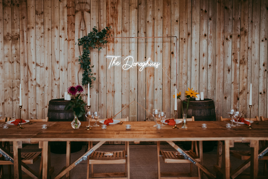 Autumnal wedding reception set up with neon light reading 'The Donoghue's' at Boreland Loch Tay