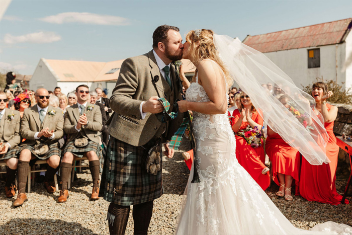 Bride and groom kiss during hand-fasting ceremony