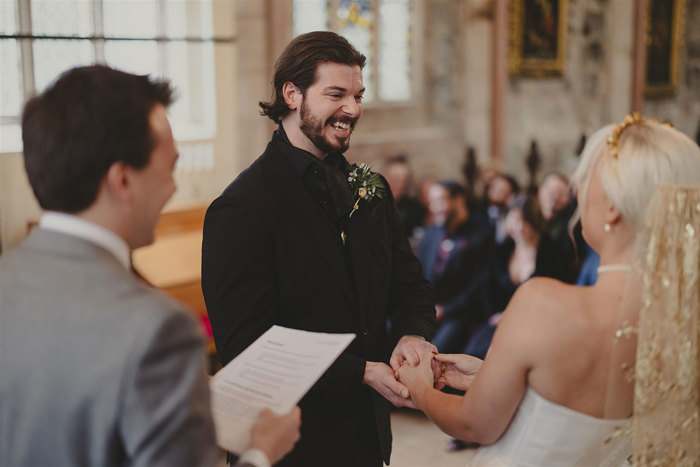 A person in a suit holding hands with a person in a church.