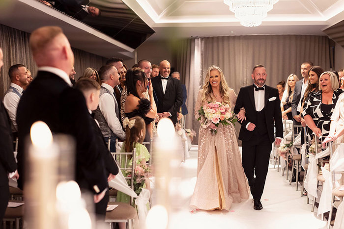 a bride walking down aisle on arm of a person at the Torrance Hotel