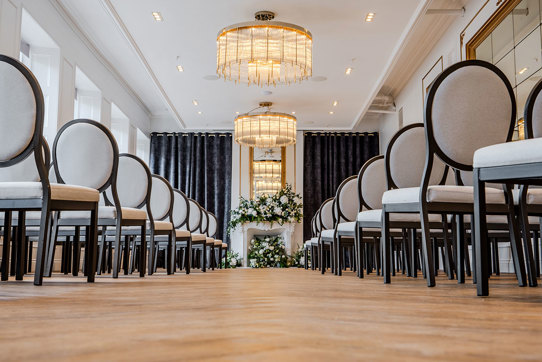 long shot of wedding aisle with seating and flowers on fireplace at the exchange