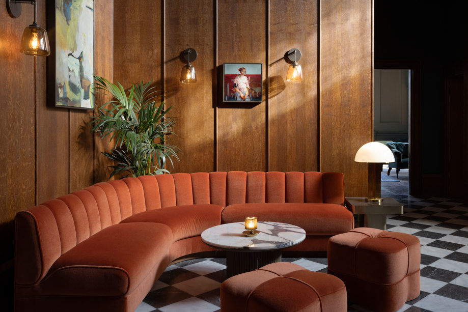 mar hall reception area with large orange couch and marble table