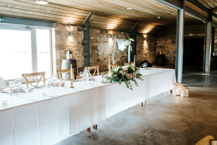 long table with white table cloth set for dinner