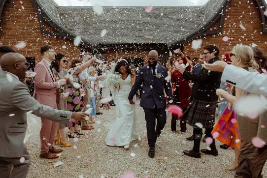 A Bride And Groom Being Showered In Confetti Outside Dougarie Boathouse