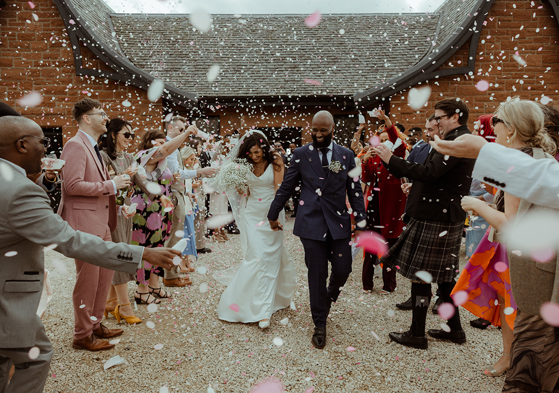 A Bride And Groom Being Showered In Confetti Outside Dougarie Boathouse