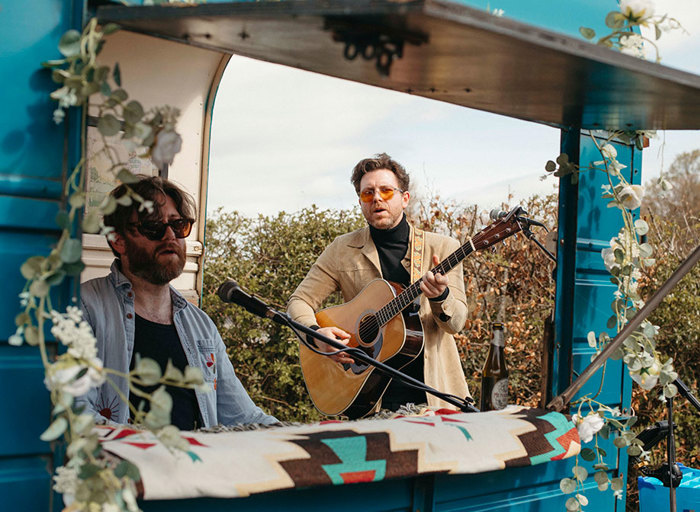 A man playing guitar and a man playing piano at Rusty's Piano Bar blue horsebox