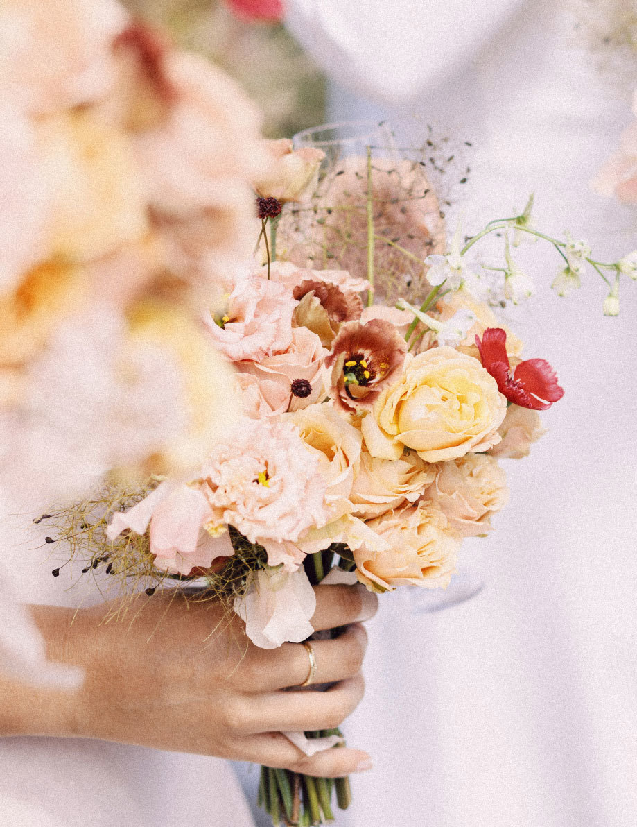 a pretty pastel bouquet of flowers held by a bride